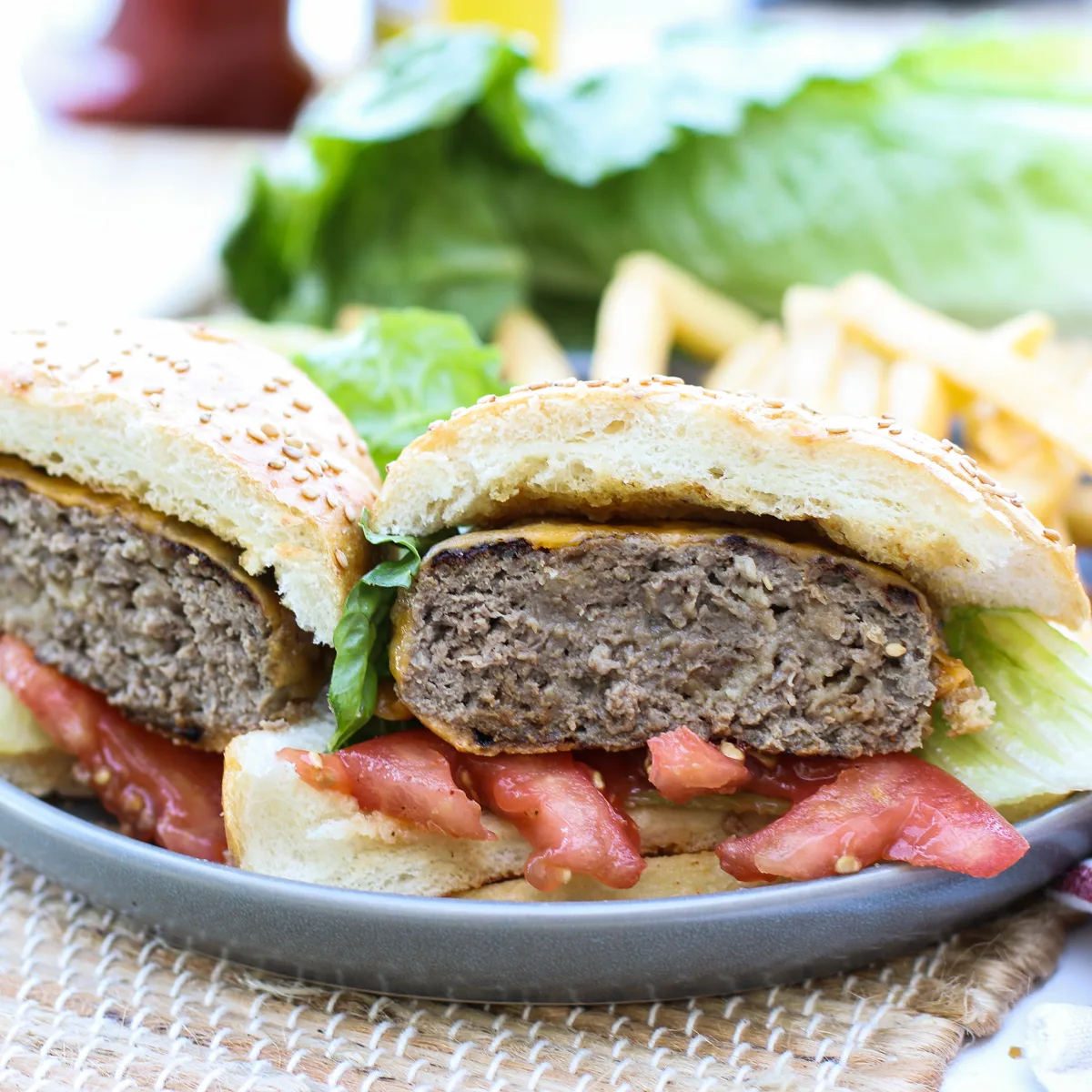 Best Elk Burger Recipe on a bun with lettuce, tomato, and cheese.