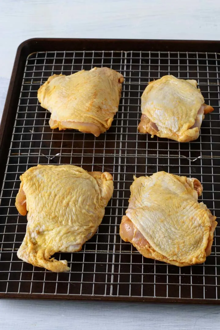 Chicken thighs on a baking pan after marinading and rinsed then dried.